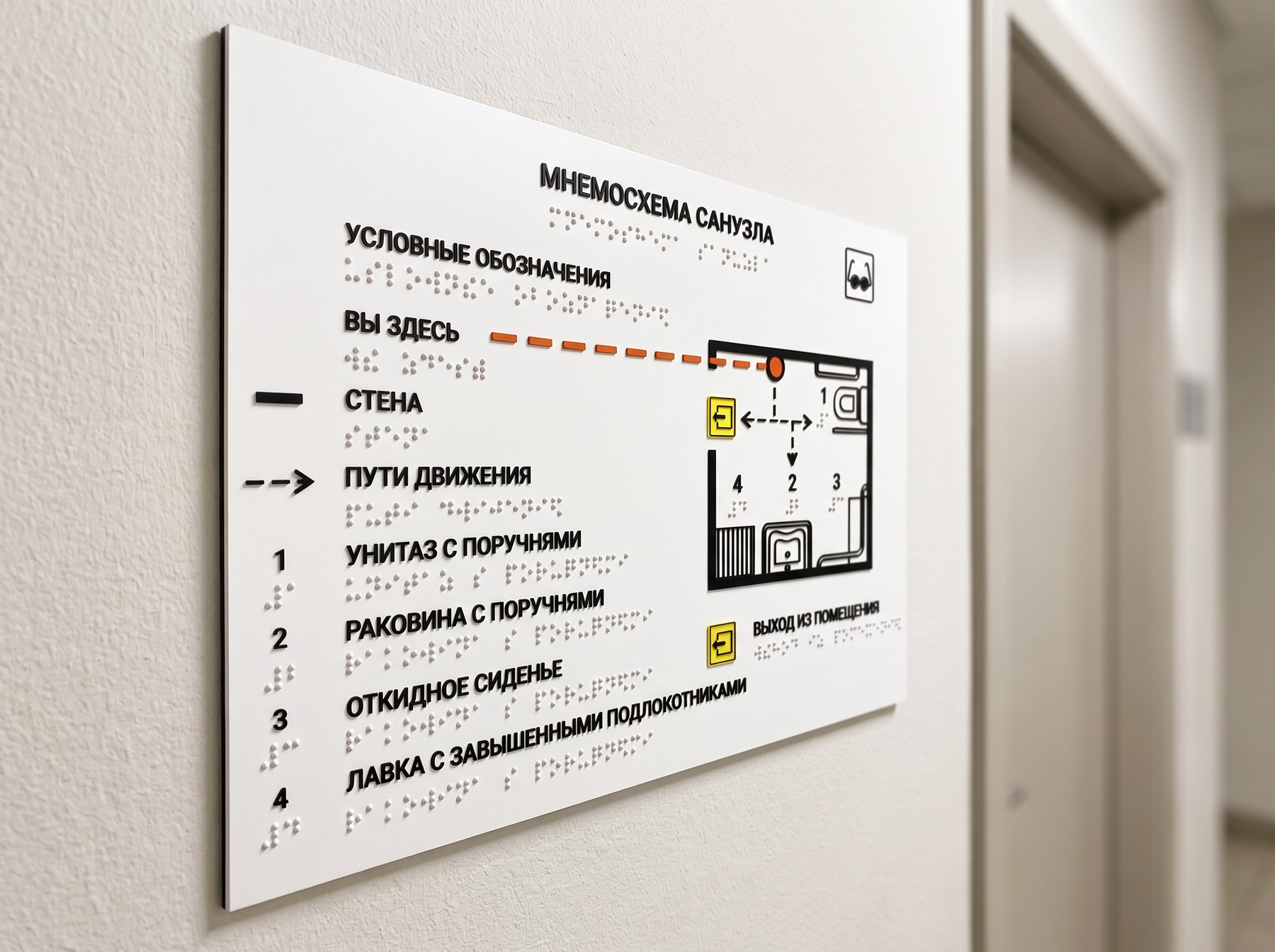 Тактильная мнемосхема санузла 300×200 мм на стене у двери: рельефный план с унитазом и раковиной с поручнями, выпуклые точки шрифта Брайля