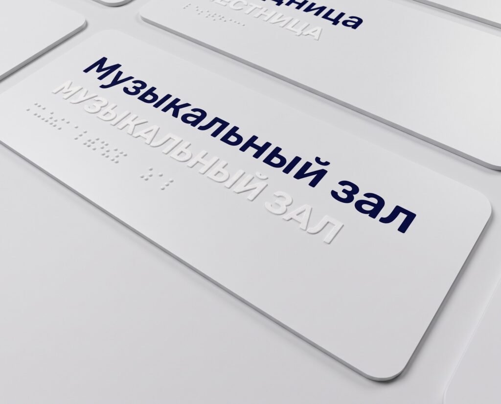 Тактильная табличка «Музыкальный зал» для детского сада: плоскопечатное наименование синим, дублирование рельефными прописными и шрифтом Брайля